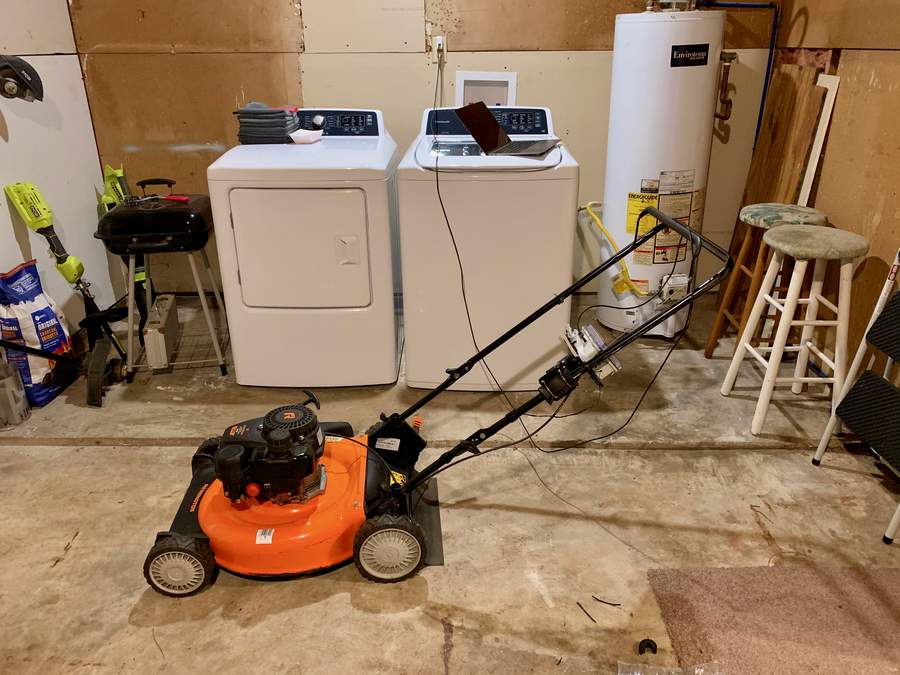 Lawnmower with laptop in garage.